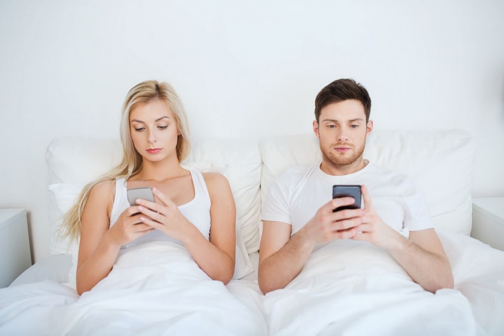 cell-phone-couple-bed